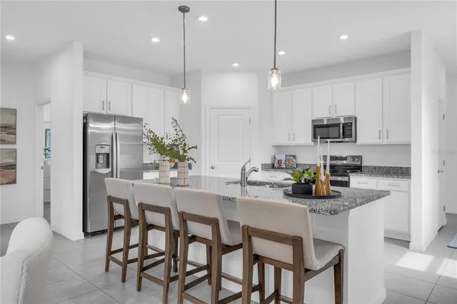 a kitchen with kitchen island granite countertop a table and chairs in it