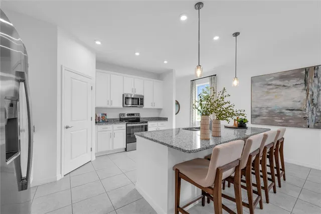 a kitchen with kitchen island a counter top space appliances and cabinets