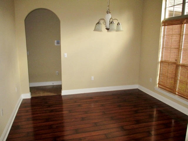 511 Pheasant Trail Crestview, FL 32536 - Photo 11 of 50 an empty room with wooden floor and windows