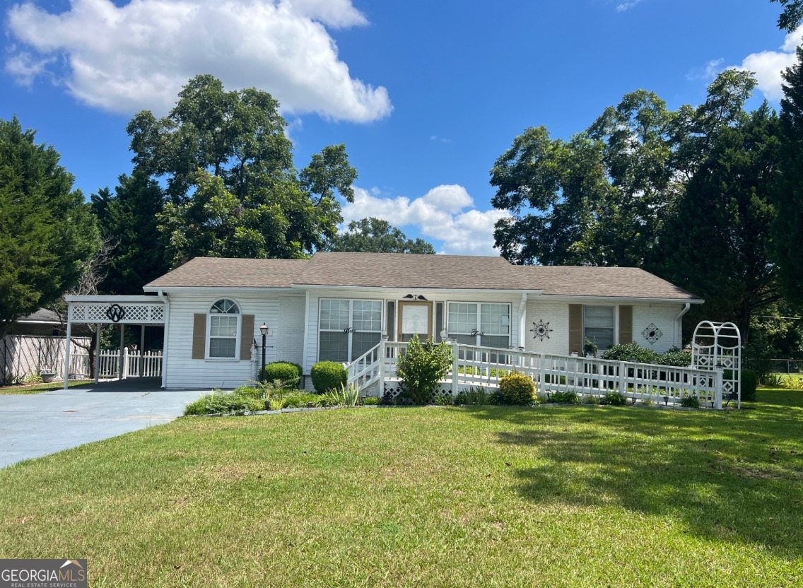 a front view of a house with garden and trees