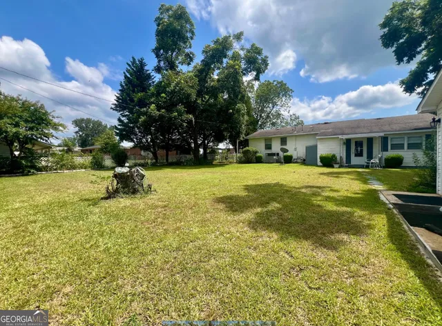 a view of a house with a swimming pool and a yard