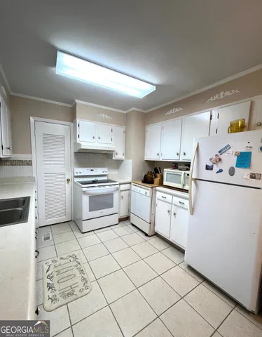 a kitchen with granite countertop cabinets and white appliances