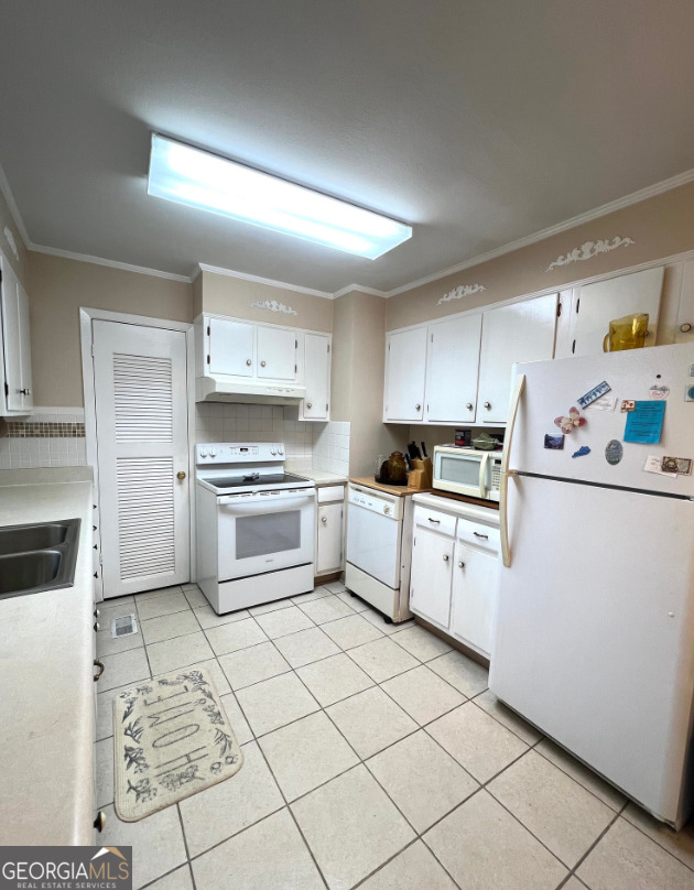 415 Riddleville Road Sandersville, GA 31082 - Photo 9 of 19 a kitchen with granite countertop cabinets and white appliances