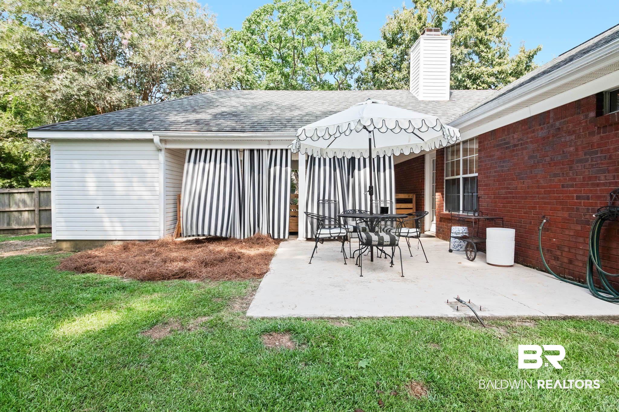 20685 Lowry Drive Fairhope, AL 36532 - Photo 45 of 48 Back of house featuring a chimney, a shingled roof, a patio area, and brick siding