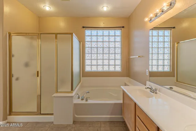 a view of a white house with large windows and wooden fence