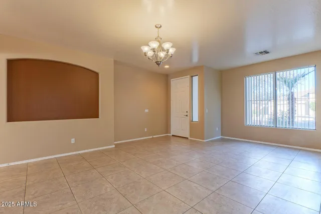a view of a livingroom with a chandelier fan and windows