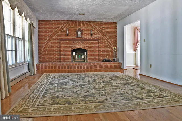 a view of empty room with wooden floor and fireplace