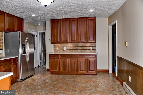 a kitchen with stainless steel appliances granite countertop wooden cabinets a refrigerator and a sink