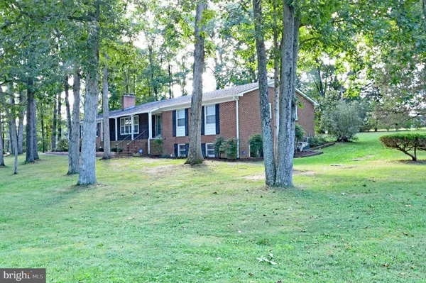 a view of a house with backyard and a tree