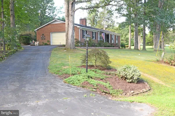 a front view of a house with a yard and trees