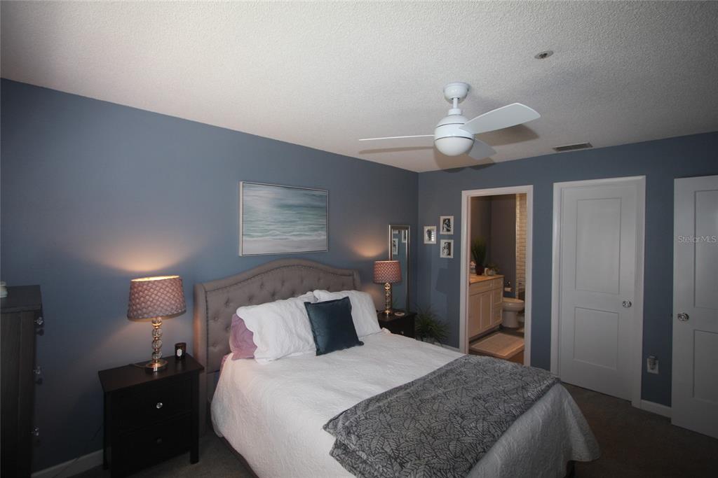 810 Loch Calder, Unit 25 Apopka, FL 32712 - Photo 12 of 24 a bedroom with a bed and a chandelier