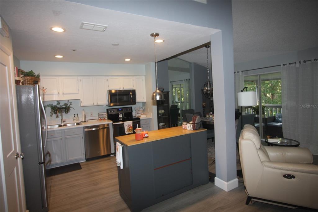 810 Loch Calder, Unit 25 Apopka, FL 32712 - Photo 3 of 24 a kitchen with stainless steel appliances kitchen island granite countertop a refrigerator a stove top oven a sink and dishwasher