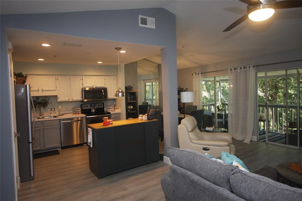 810 Loch Calder, Unit 25 Apopka, FL 32712 - Photo 8 of 24 a living room with stainless steel appliances kitchen island granite countertop a refrigerator a stove top oven a sink with wooden floor and cabinets