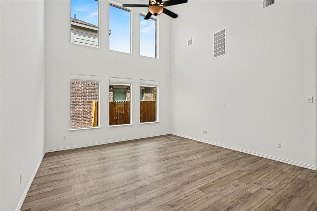 10004 Thornapple Road Fort Worth, TX 76179 - Photo 6 of 39 a view of an empty room with a window and wooden floor