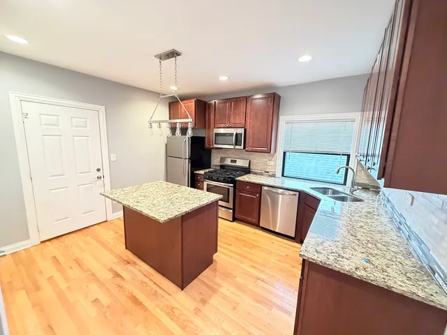 a kitchen with stainless steel appliances granite countertop a sink stove and refrigerator