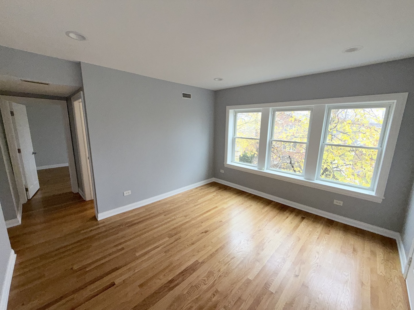 4204 North Melvina Avenue, Unit 2 Chicago, IL 60634 - Photo 5 of 12 an empty room with wooden floor and windows