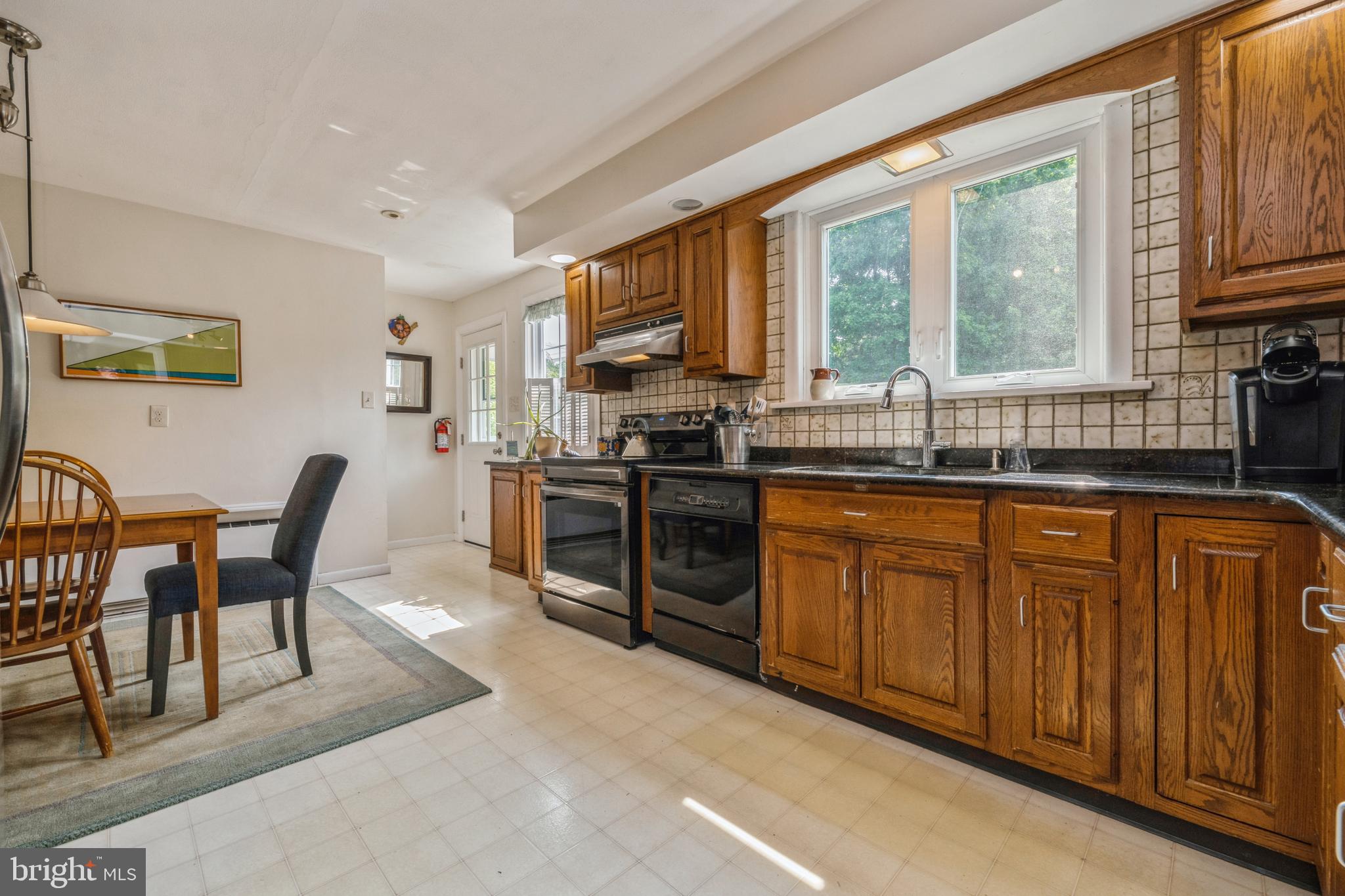7 Perry Drive Ewing, NJ 08628 - Photo 14 of 39 a kitchen with stainless steel appliances granite countertop wooden cabinets a stove a sink a dining table and chairs
