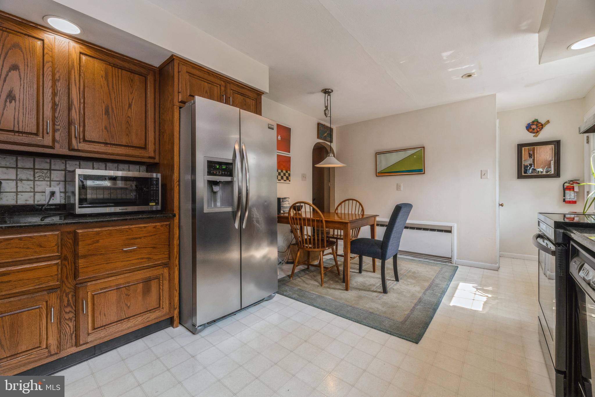 7 Perry Drive Ewing, NJ 08628 - Photo 17 of 39 a kitchen with stainless steel appliances granite countertop a refrigerator a stove a sink a dining table and chairs with wooden floor