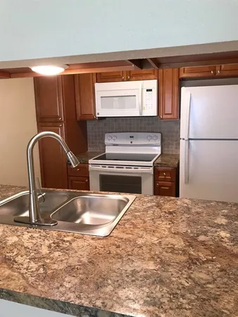 a kitchen with granite countertop a sink and a refrigerator