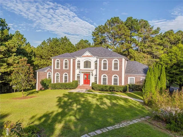 a front view of a house with a garden