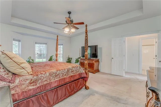 a bedroom with a bed a flat screen tv and a chandelier