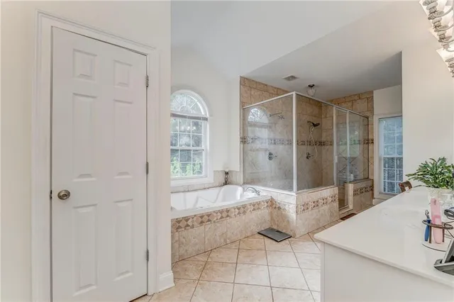 a spacious bathroom with a tub shower and sink
