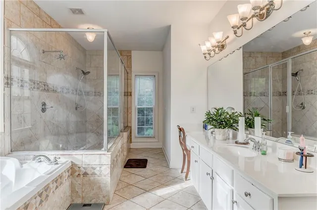 a spacious bathroom with a granite countertop tub a sink and mirror