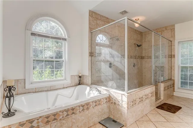 a bathroom with a granite countertop tub shower and sink
