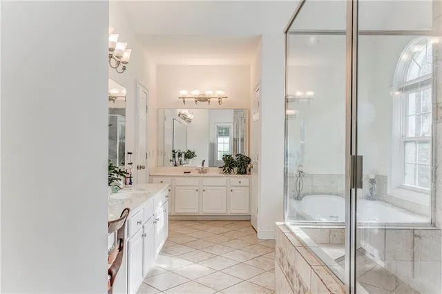 a bathroom with a granite countertop sink a mirror and a bathtub