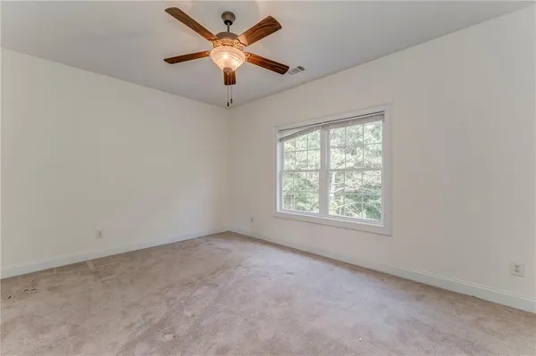 an empty room with a window and a fan