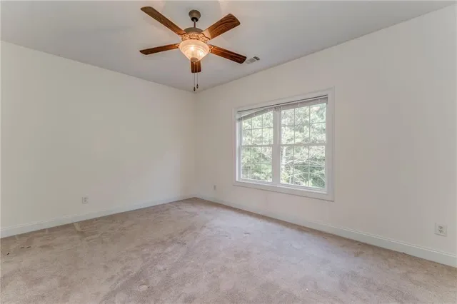 an empty room with a window and a fan