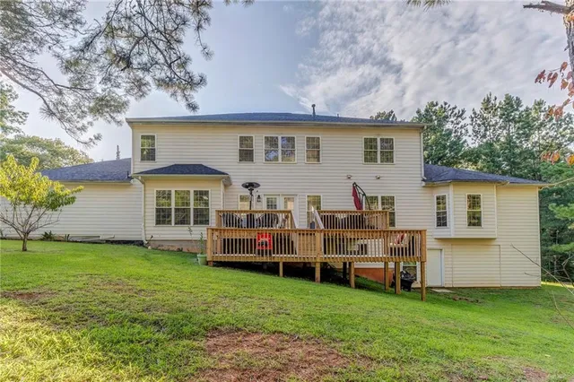 a view of a house with backyard and a tree