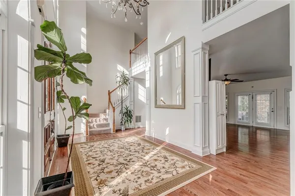 a view of a hallway with wooden floor and a potted plant
