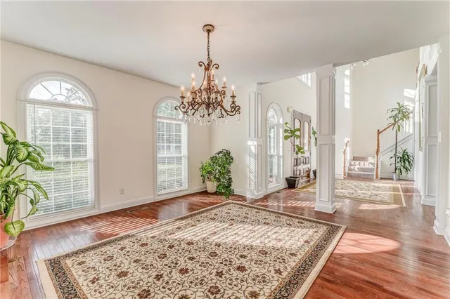 a view of a hallway with wooden floor and a chandelier
