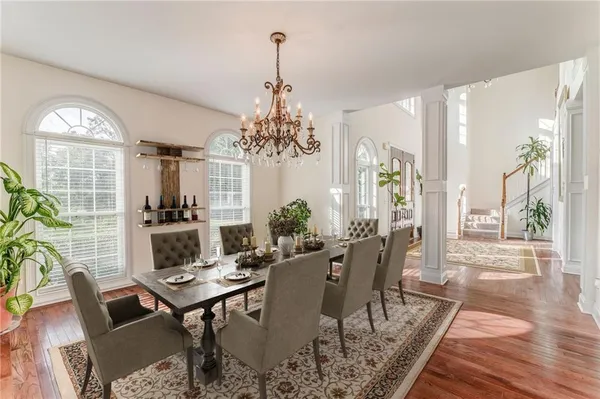 a view of a dining room with furniture a chandelier and wooden floor