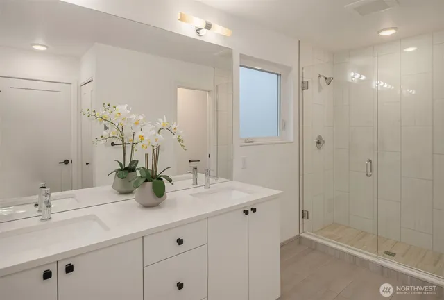 a bathroom with a shower sink vanity and mirror
