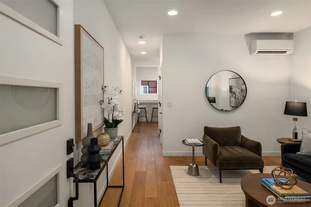 a living room with furniture a clock on wall and a table