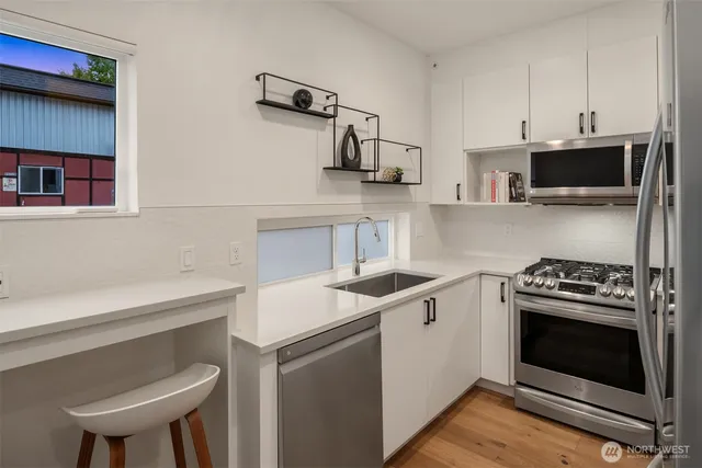 a kitchen with stainless steel appliances a stove a sink and a microwave