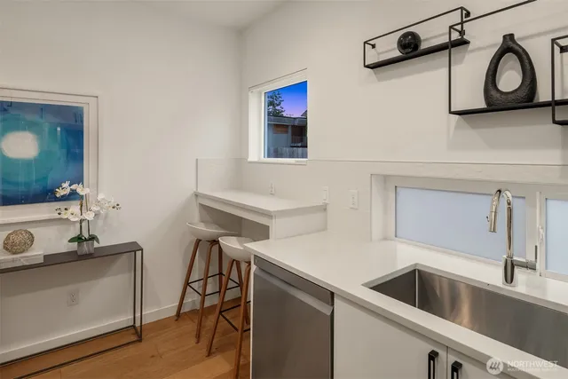 a kitchen with a sink and a stove with wooden floor