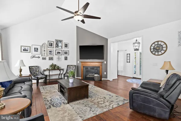 a kitchen with stainless steel appliances granite countertop a stove top oven a sink a dining table and chairs with wooden floor