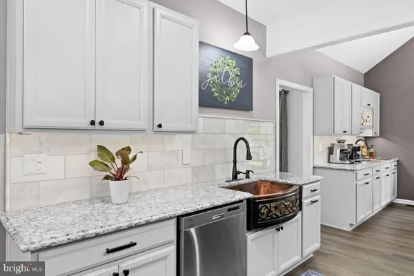 a kitchen with white cabinets and a sink