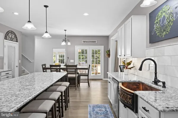 a large kitchen with granite countertop lots of counter space dining table and stainless steel appliances