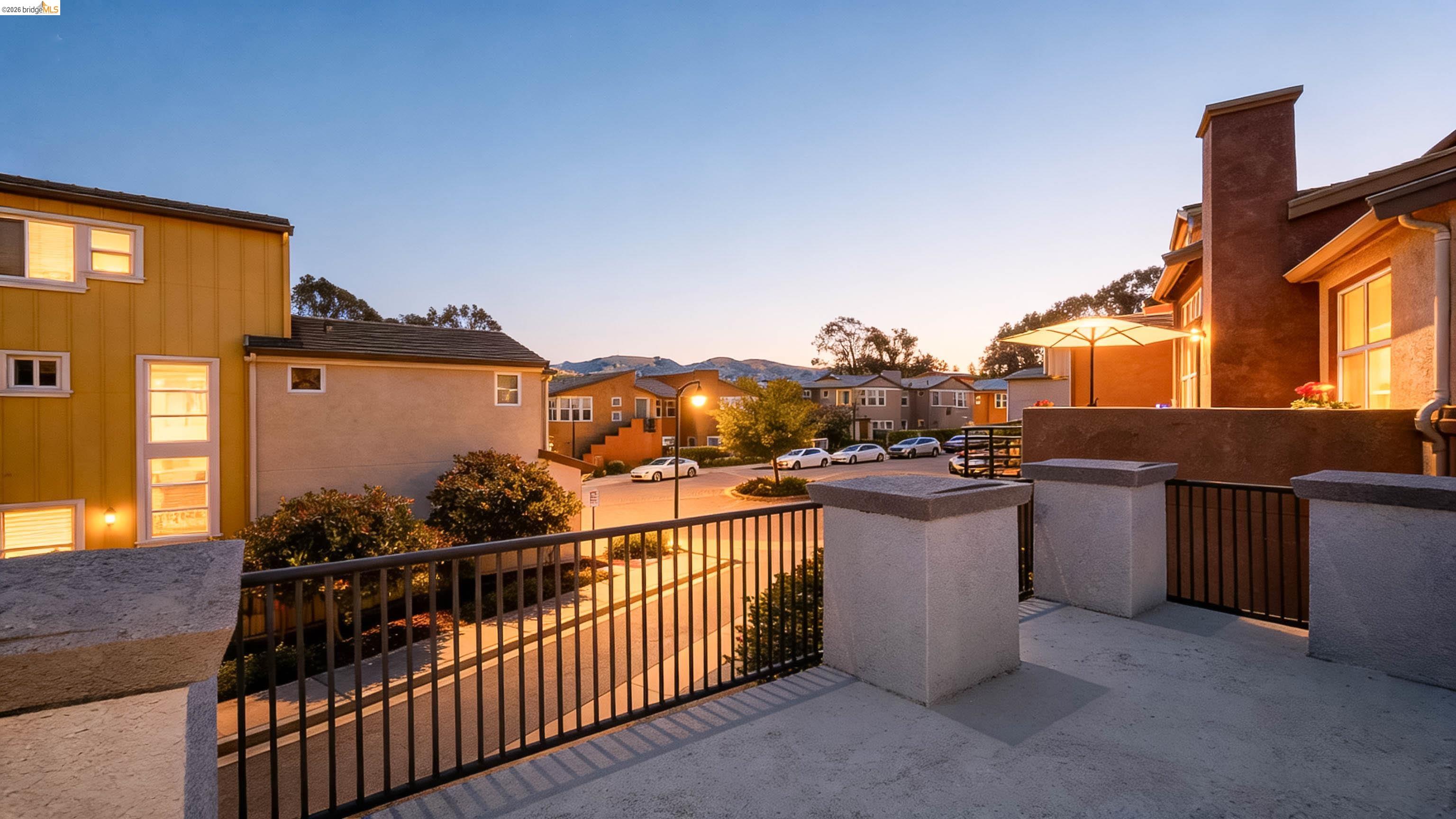 449 Constantine Court San Ramon, CA 94583 - Photo 4 of 63 Outdoor patio featuring a concrete surface, black metal railing, and stucco-finished pillars