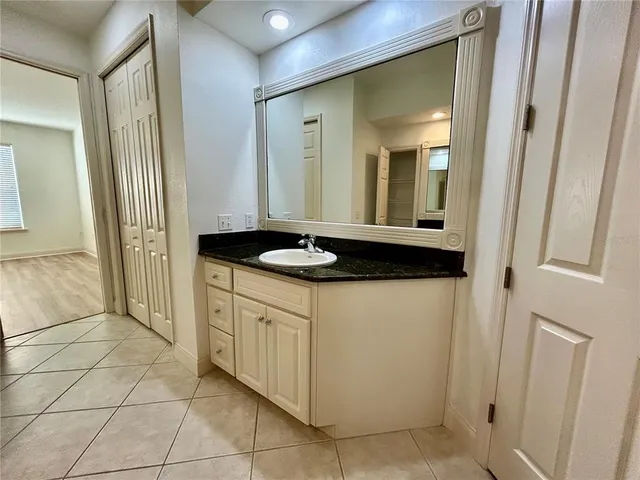 a bathroom with a granite countertop sink and a mirror