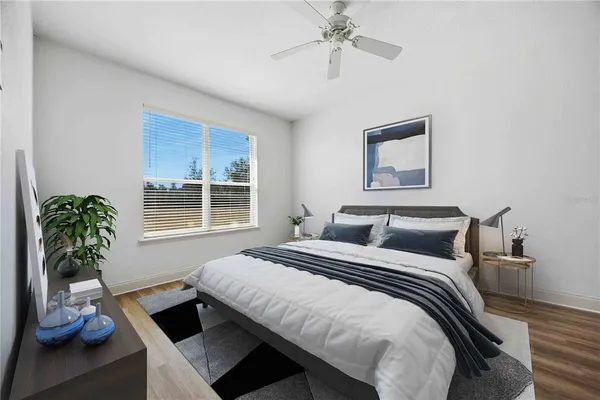 a bedroom with a bed and a potted plant