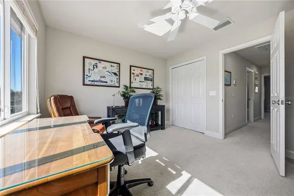 a view of a workspace with furniture and a window