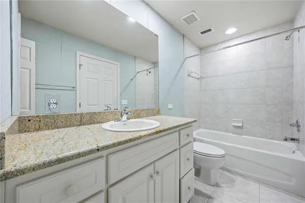 a bathroom with a granite countertop sink a toilet and bathtub