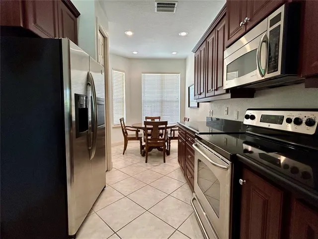 a kitchen with stainless steel appliances granite countertop a refrigerator a sink a stove and cabinets