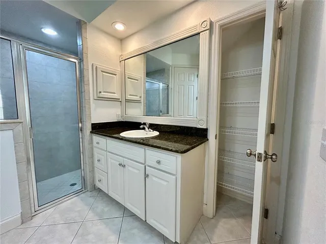 a bathroom with a shower sink and mirror