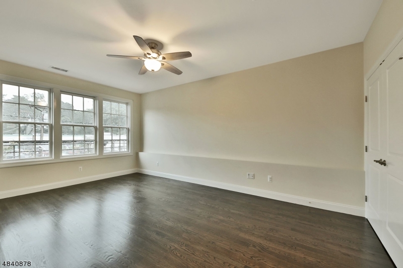115 Watchung Avenue, Unit 1 Montclair, NJ 07043 - Photo 14 of 15 an empty room with wooden floor fan and windows
